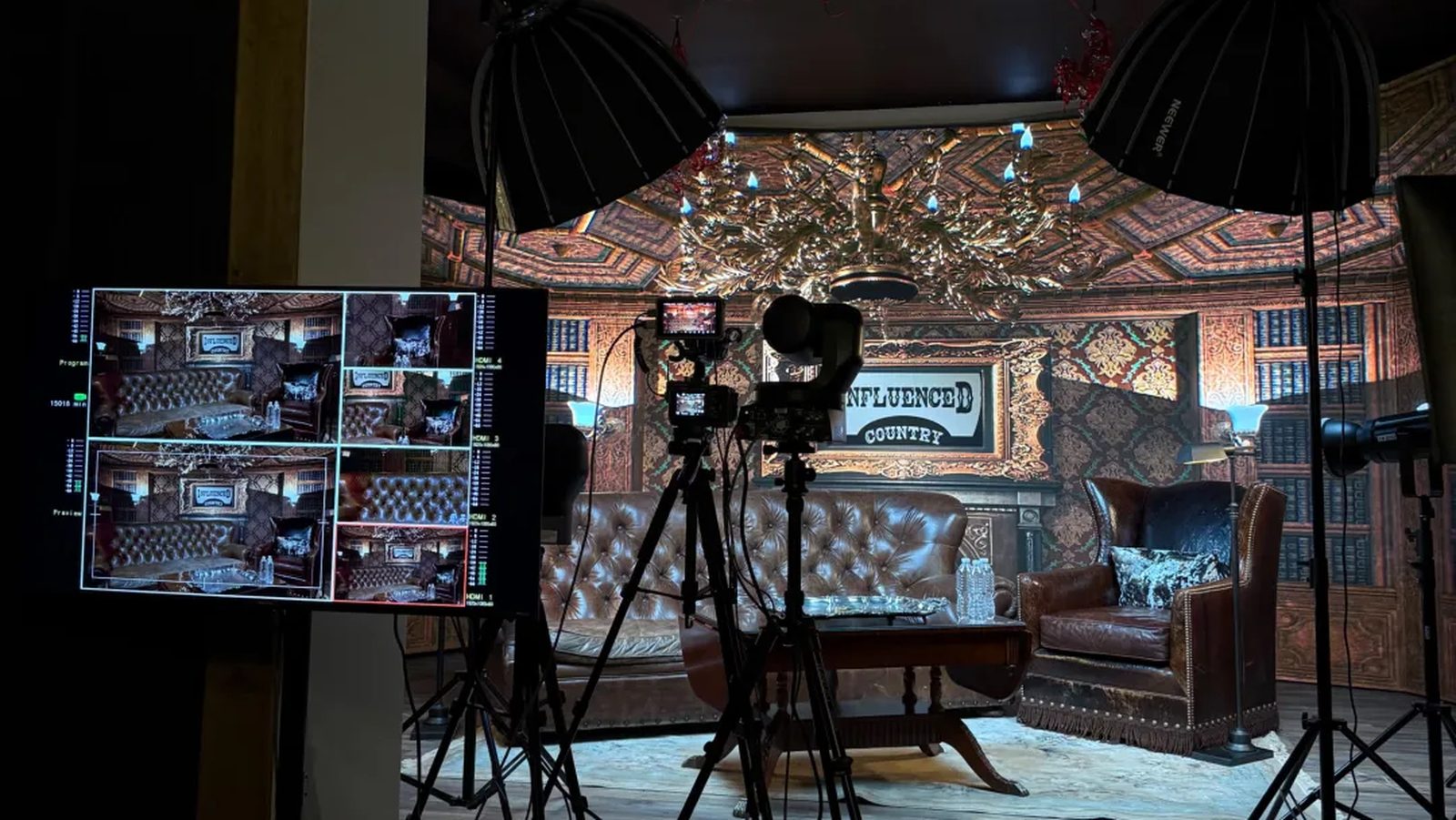 A talk-show set on the LED wall stage, with leather chairs, cameras on tripods and a multiview monitor